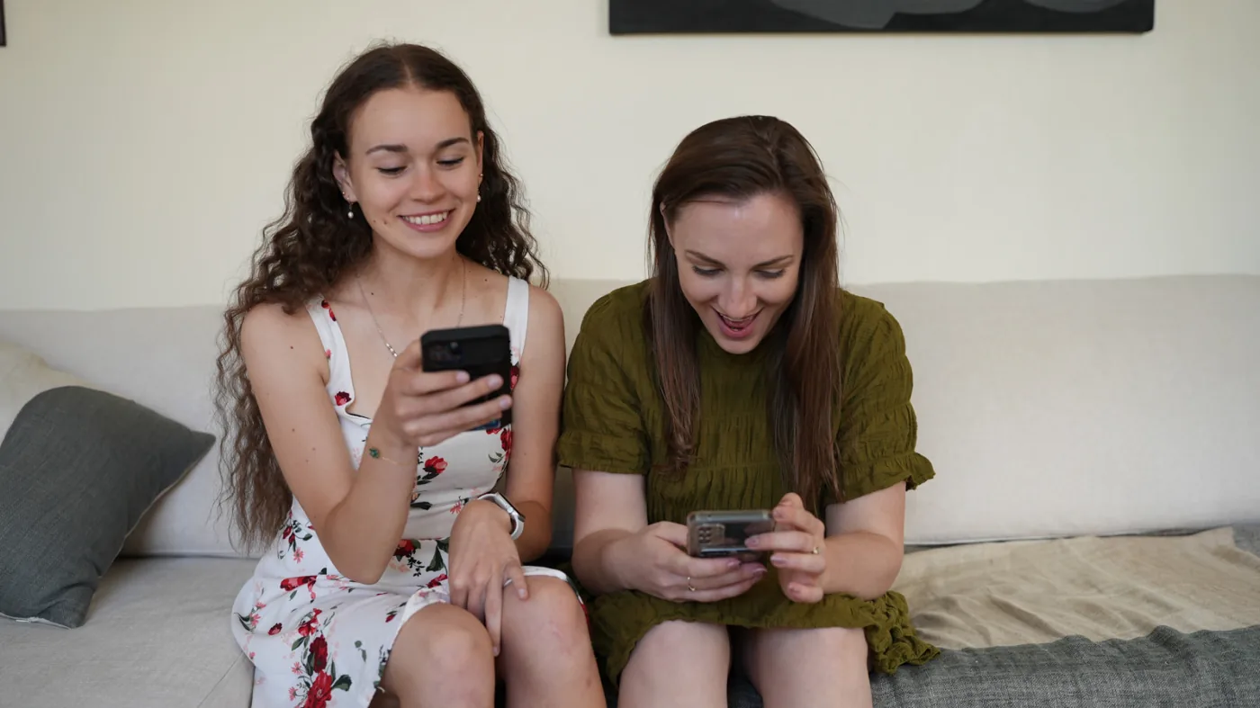 Two women smiling while using the Endo45 app on their phones